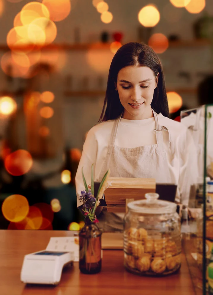Woman at cash register in cafe, bokeh background