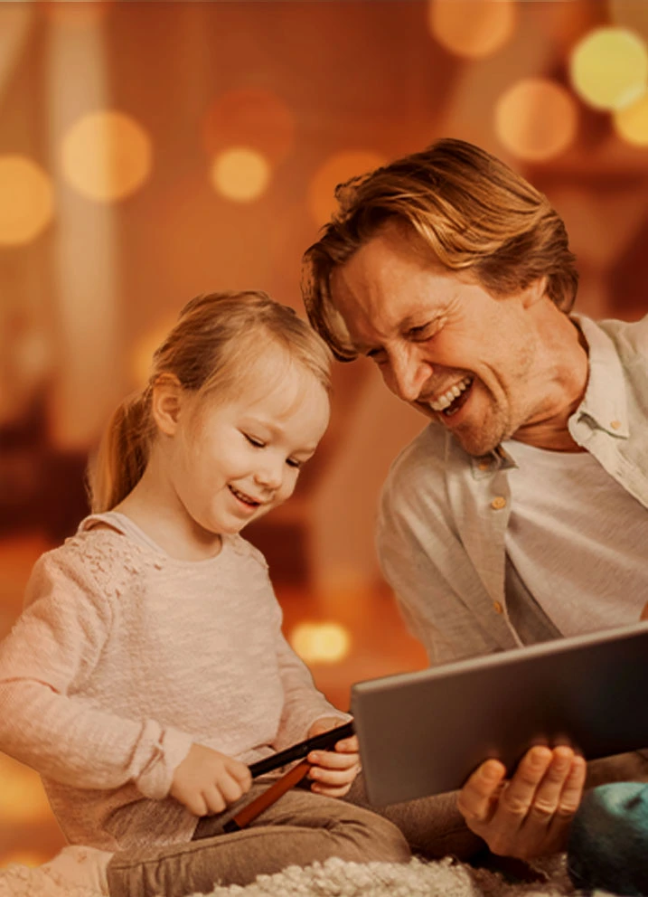Father and daughter using tablet together, bokeh background