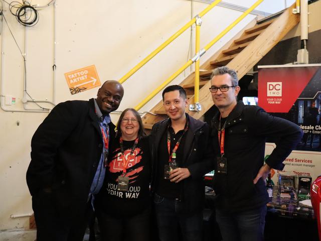 A group of four business people at the Pentafest, smiling at the camera