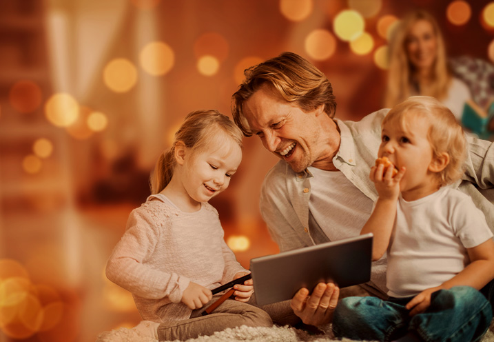Father and children using tablet together, bokeh background