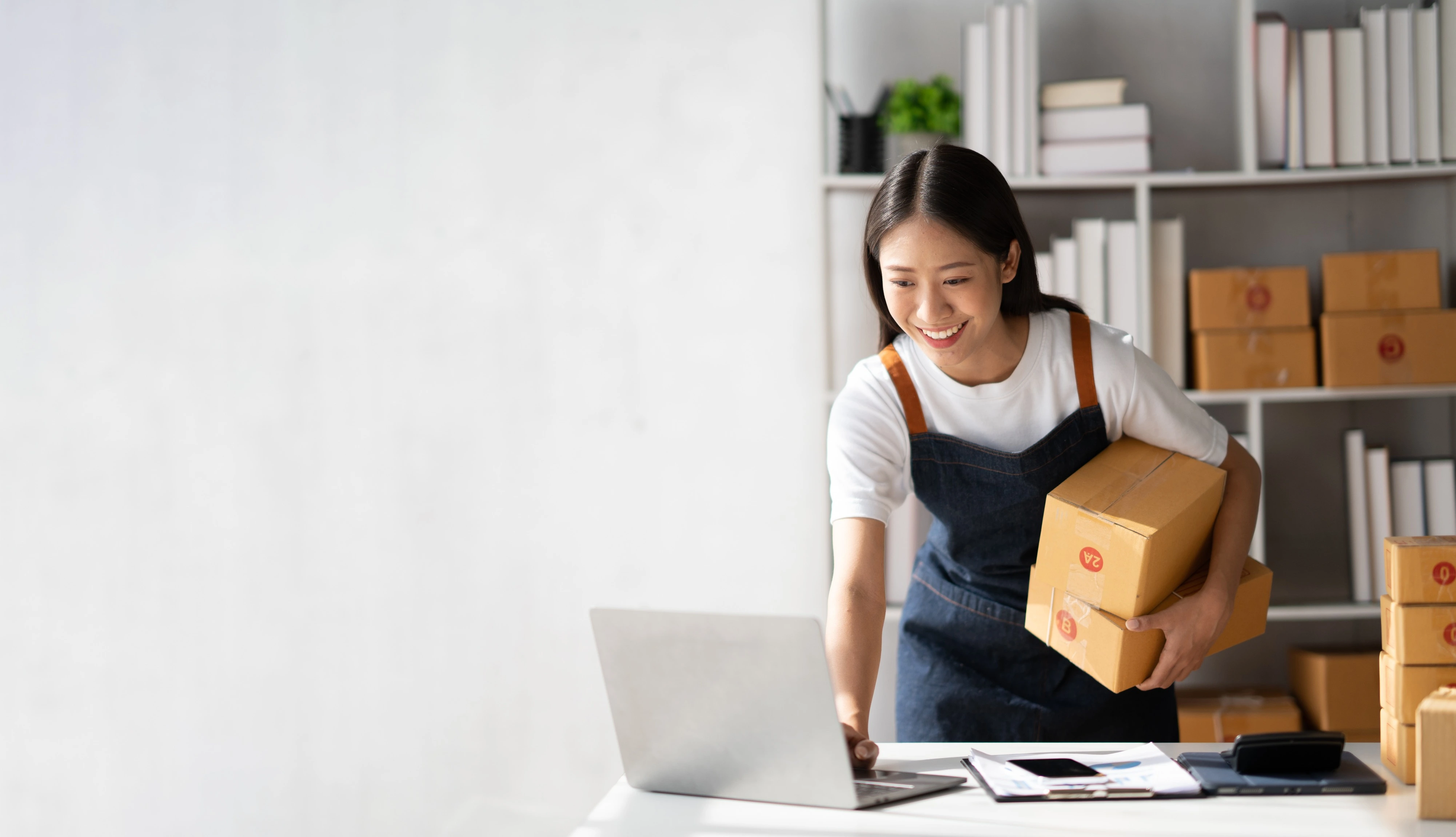 woman holding box working on computer